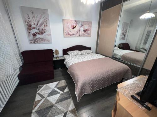 Dormitorio pequeño con cama y espejo en Hardy's Apartment, en Belgrado