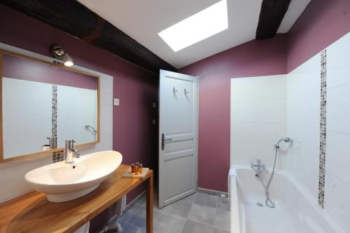 a bathroom with a sink and a tub and a mirror at Logis Hôtel Château De Palaja in Carcassonne