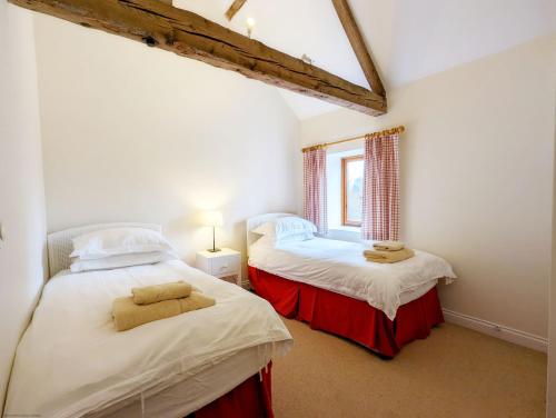 two twin beds in a room with a window at Old Root House, Lavant in Chichester