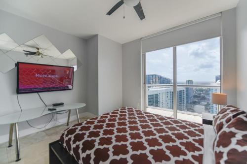 a bedroom with a bed and a desk and a tv at Wonderful 2/2 Condo at Icon Brickell With Pool in Miami