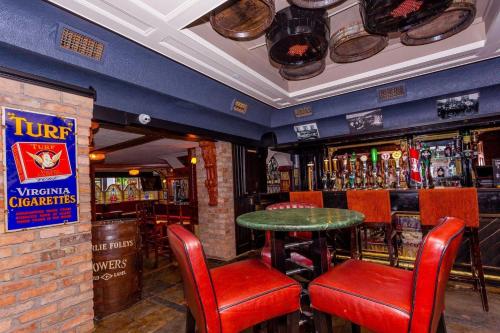 un bar con sillas rojas y una mesa verde en Charlie Foleys en Killarney