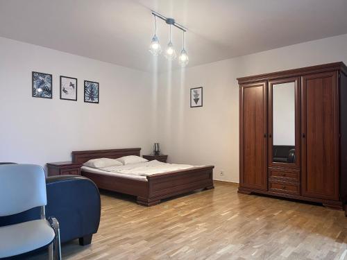 sypialnia z łóżkiem, szafką i krzesłem w obiekcie Apartamenty Centrum w mieście Białystok