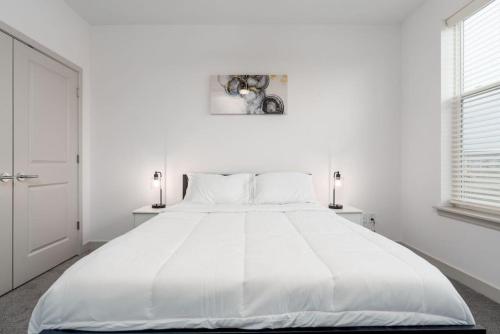 uma grande cama branca num quarto branco com 2 candeeiros em Lovely Private bedroom - Shared em Whitestown