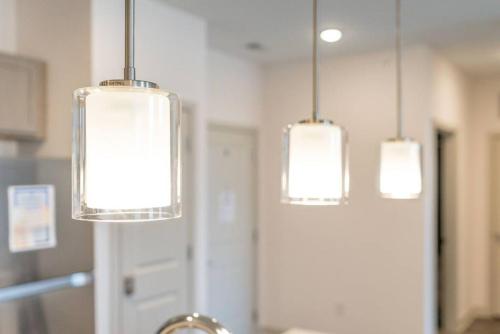 three lights hanging from the ceiling in a kitchen at Lovely Private bedroom - Shared in Whitestown