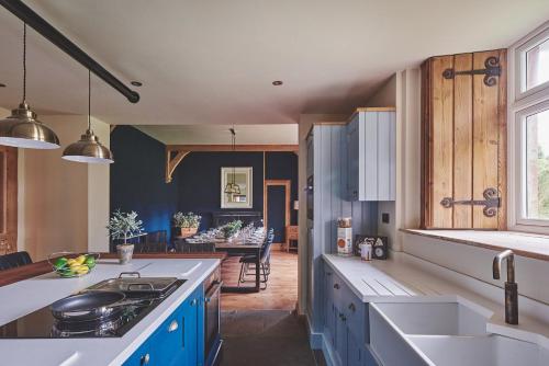 a kitchen with blue cabinets and a counter top at The Old Vicarage in Holmrook