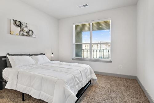 - une chambre blanche avec un grand lit et une fenêtre dans l'établissement Luxurious 2-Bedroom, Whitestown, à Whitestown