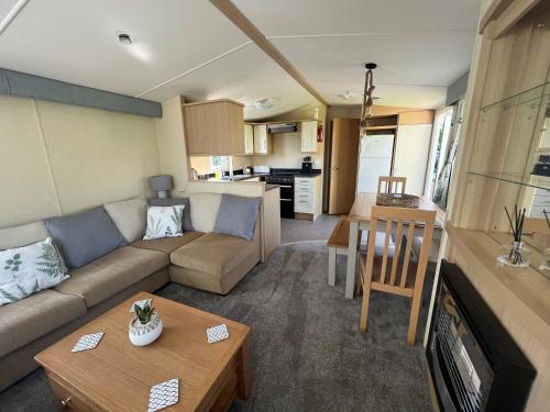 ein Wohnzimmer mit einem Sofa und einem Tisch in der Unterkunft Polladras Holiday Park in Helston