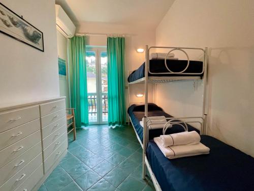 a bedroom with two bunk beds and green curtains at Casa di MARI - Appartamento con grande terrazza in Sperlonga