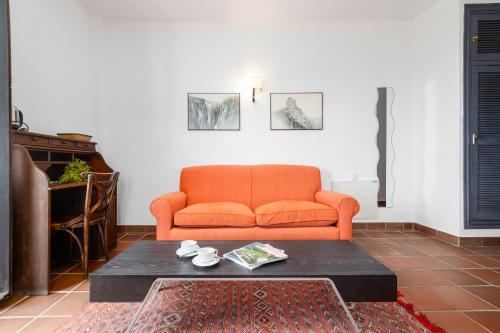 an orange couch in a living room with a coffee table at Cerro de Hijar in Tolox