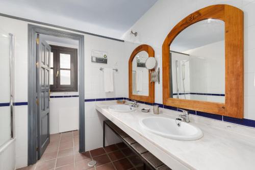 uma casa de banho com 2 lavatórios e um espelho grande em Cerro de Hijar em Tolox