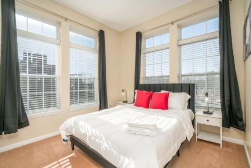 a bedroom with a large white bed with red pillows at Lovely 3BD 3BA Downtown Indy in Indianapolis