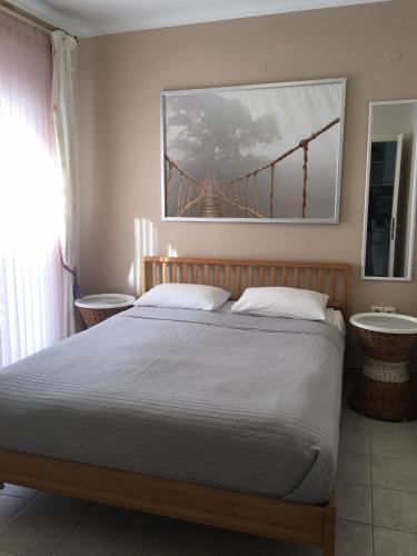 a bedroom with a bed with a bridge painting on the wall at Seaflows Apartments #3 in Paralia Katerinis