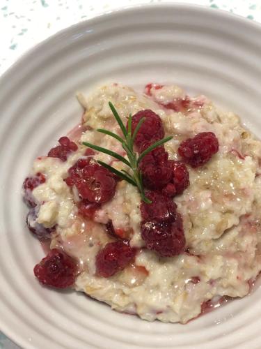 a white plate of food with raspberries on it at Edgcott House in Exford