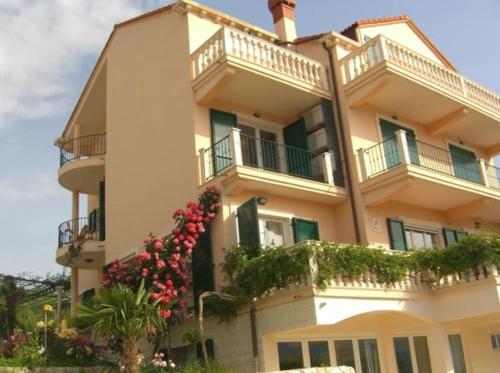a building with balconies and flowers on it at Vila Lukić in Slano