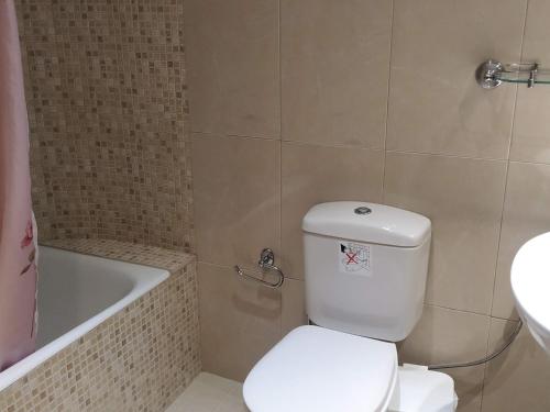 uma casa de banho com um WC, uma banheira e um lavatório. em Family House em Agios Nikolaos