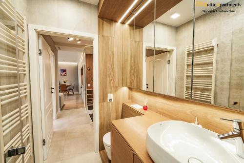 a bathroom with a sink and a mirror at Baltic Apartments - Apartamenty Bałtyk in Świnoujście