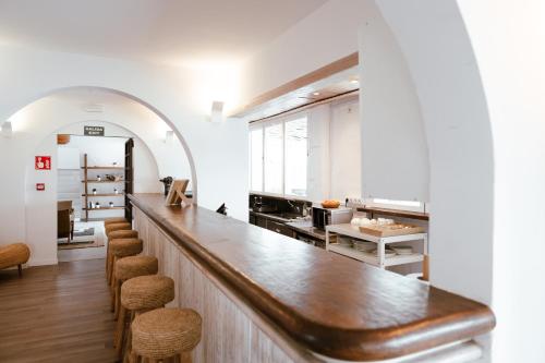 a large kitchen with a long counter and stools at Outsite Ibiza in Es Cana
