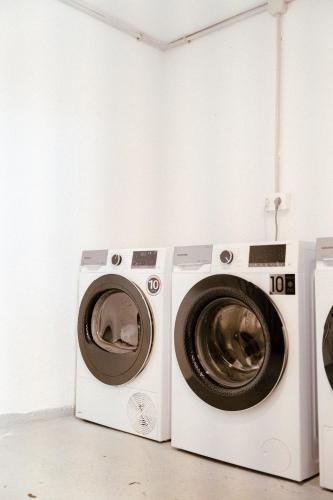 two washing machines sitting next to each other in a room at Outsite Ibiza in Es Cana
