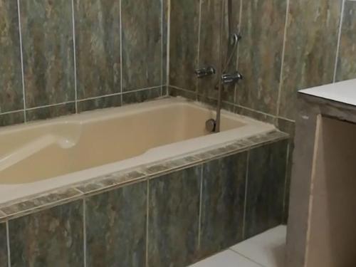 a bath tub with a faucet in a bathroom at Sunrise Hostel Farallon in Río Hato