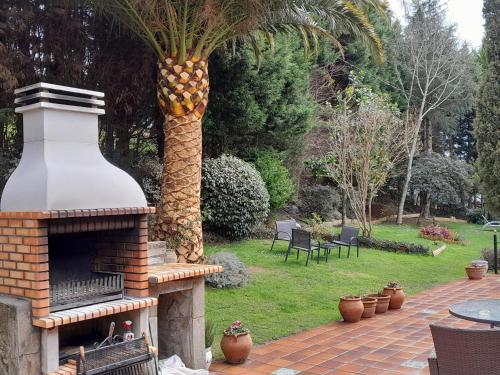 a palm tree with a fireplace in a garden at Urrezko Ametsa in Sopuerta