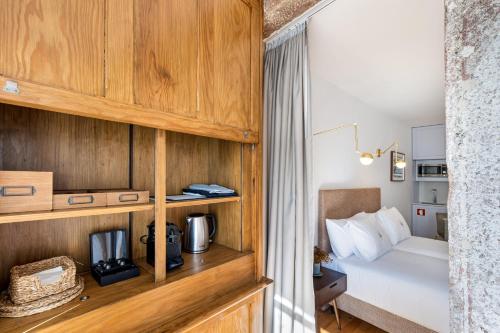LP Heritage Apartments في براغا: غرفة نوم بسرير وجدار خشبي