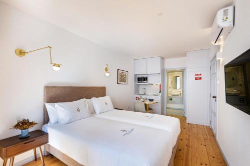 a bedroom with a large white bed with a wooden floor at LP Heritage Apartments next to Braga Cathedral by Sé Apartamentos in Braga