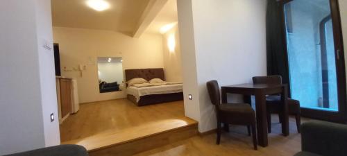 a living room with a table and a bed at Beautiful View Of Sarajevo Center in Sarajevo