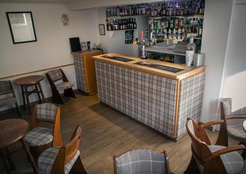 a bar in a restaurant with tables and chairs at The Rhiconich Hotel in Kinlochbervie