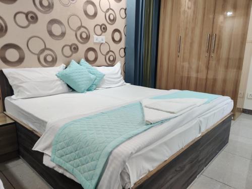 1 dormitorio con 1 cama con almohadas azules y blancas en Dev Residency, en Gurgaon