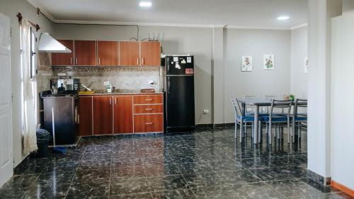 een keuken met een tafel en een zwarte koelkast bij Departamentos KAYLU in El Bolsón