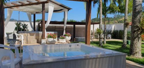 a hot tub in a backyard with a pergola at Hotel Termas Gravatal in Gravatal