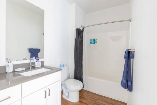 a bathroom with a toilet and a sink and a shower at Modern Upscale 1BR Fountain Square in Indianapolis