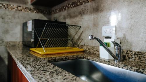 a kitchen counter with a sink and a coffee maker at Departamentos KAYLU in El Bolsón