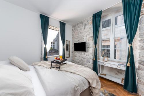 1 dormitorio con 1 cama grande y cortinas azules en Rooms Eden Old Town, en Dubrovnik