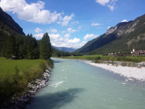 a river flows through a valley in the mountains at Gästehaus Hauser in Bach