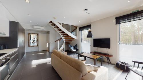 a living room with a couch and a staircase at Sandy Kelt - Irish House Apartments in Kalajoki