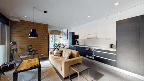 a living room with a couch and a kitchen at Sandy Kelt - Irish House Apartments in Kalajoki