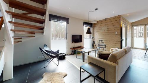 - un salon avec un canapé et une télévision dans l'établissement Sandy Kelt - Irish House Apartments, à Kalajoki