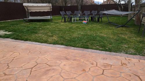 a patio with chairs and a table and a swing at Casa Beatrice in Călimăneşti