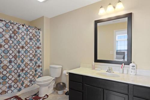 ein Badezimmer mit einem Waschbecken, einem WC und einem Spiegel in der Unterkunft Private Bed Downtown INDY - Shared in Indianapolis