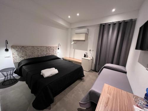 a bedroom with a black bed and a table at Villa Chiara Taormina in Taormina