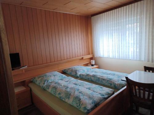 two beds in a room with wood paneling at Gasthaus zur Linde in Staufenberg