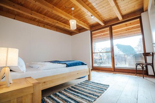 ein Schlafzimmer mit einem Bett und einem großen Fenster in der Unterkunft Naturhaus Luminus in Bad Aibling