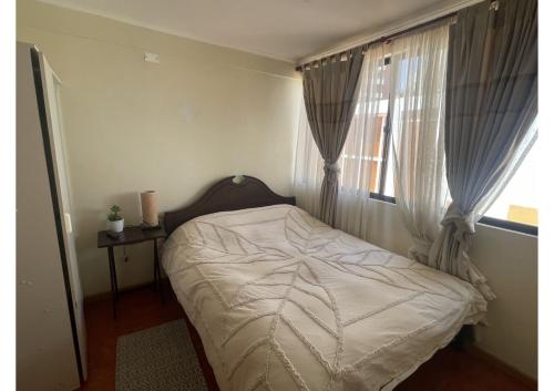 a small bedroom with a bed and a window at Hospedaje 2174 in Iquique