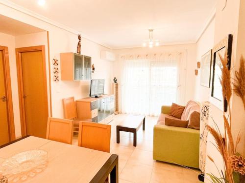 salon z kanapą i stołem w obiekcie Jardines al Mar piscina y garaje w mieście Oropesa del Mar