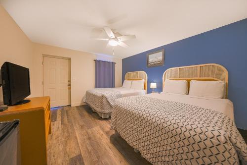 a hotel room with two beds and a flat screen tv at City Centre Motel by OYO in Seaside