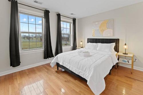 una camera con un grande letto e due finestre di Your Cozy One Bedroom Midtown a Detroit