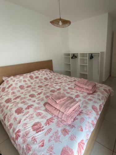 a bedroom with a bed with pink towels on it at Bel appartement entre terre et mer in Sarrola-Carcopino