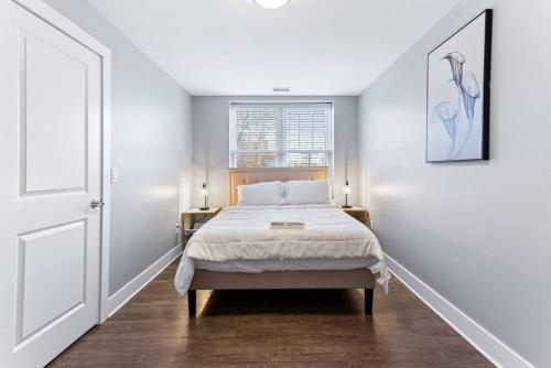 a white bedroom with a bed and a window at Your Cozy One Bedroom Midtown in Detroit