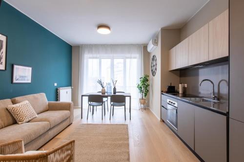 a kitchen and living room with a couch and a table at Daplace - Portaluppi Apartment in Milan